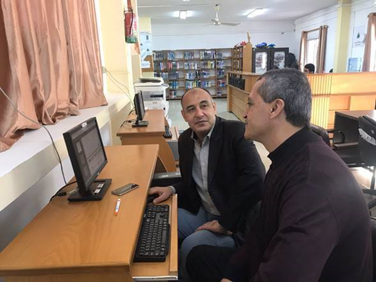 To menn som sitter ved en PC i et bibliotek